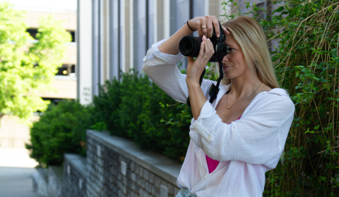 Emily Brozeski takes a picture with her camera outside of College Hall.