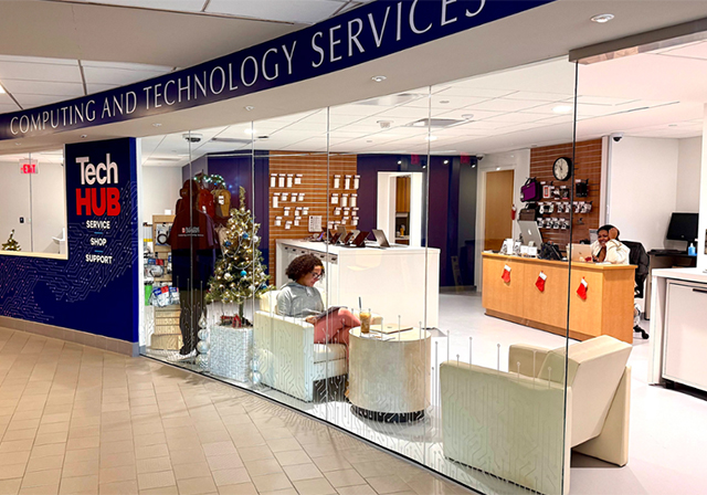 Female student works on laptop in TechHUB store front in Student Union