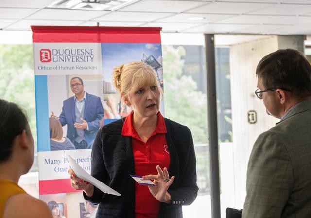 Employees chatting at hire a veteran event