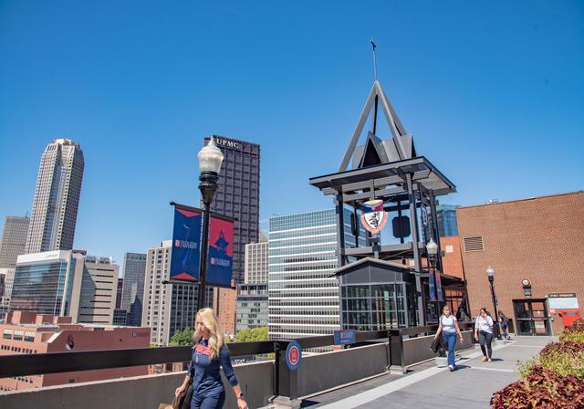 Students walking across campus with the city of Pittsburgh in the background