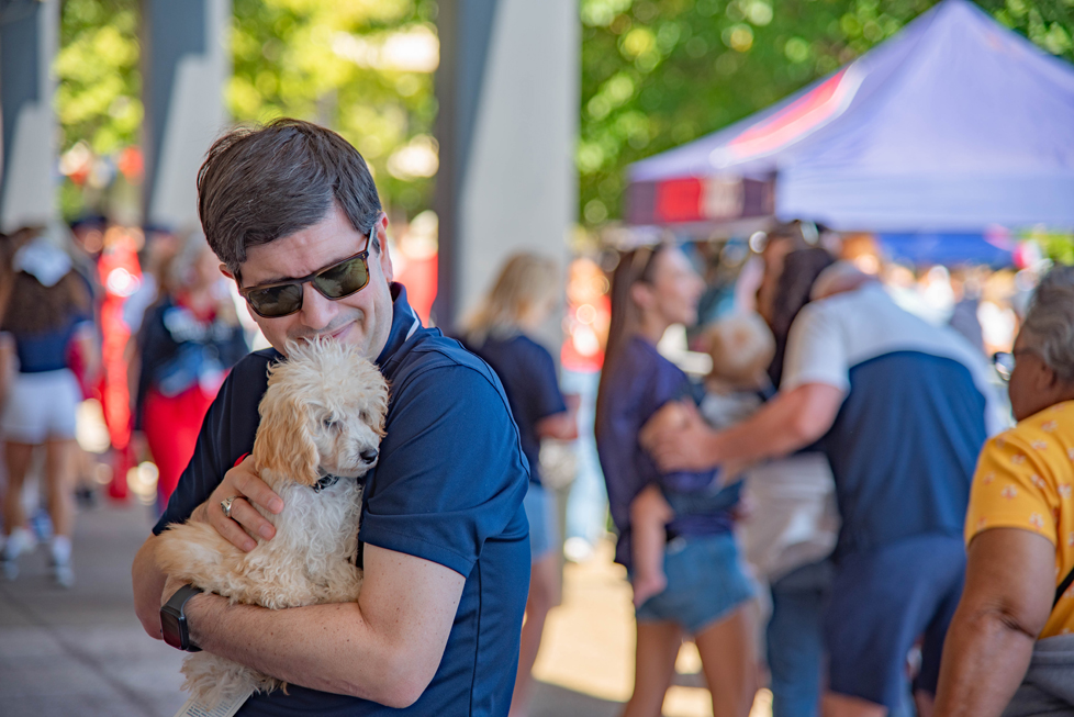 Dr. Dausey holding small dog at homecoming
