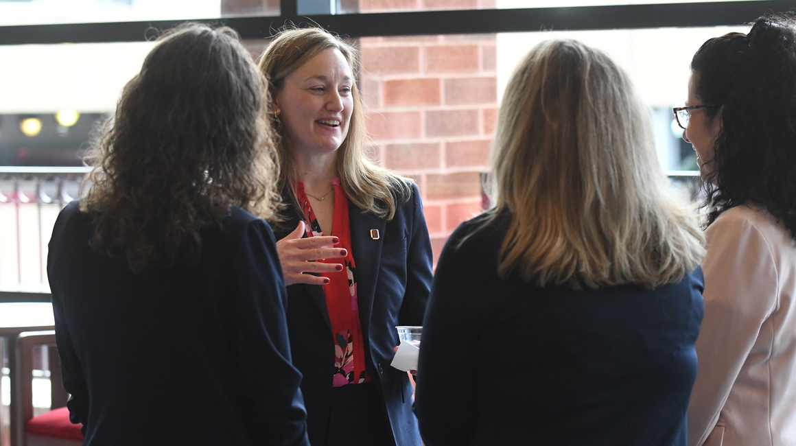 Sarah Ewing chatting with colleagues.
