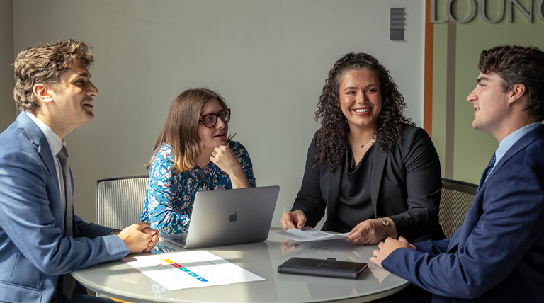 Four graduate students in a meeting.