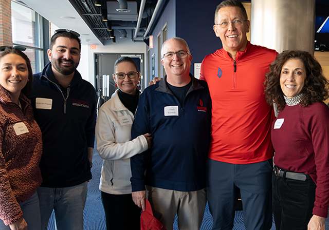 Group of Duquense alumni with Women's basketball coach.