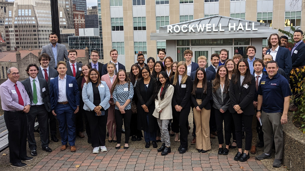 Image: SCM students, faculty, and industry experts pose outside of Rockwell Hall.