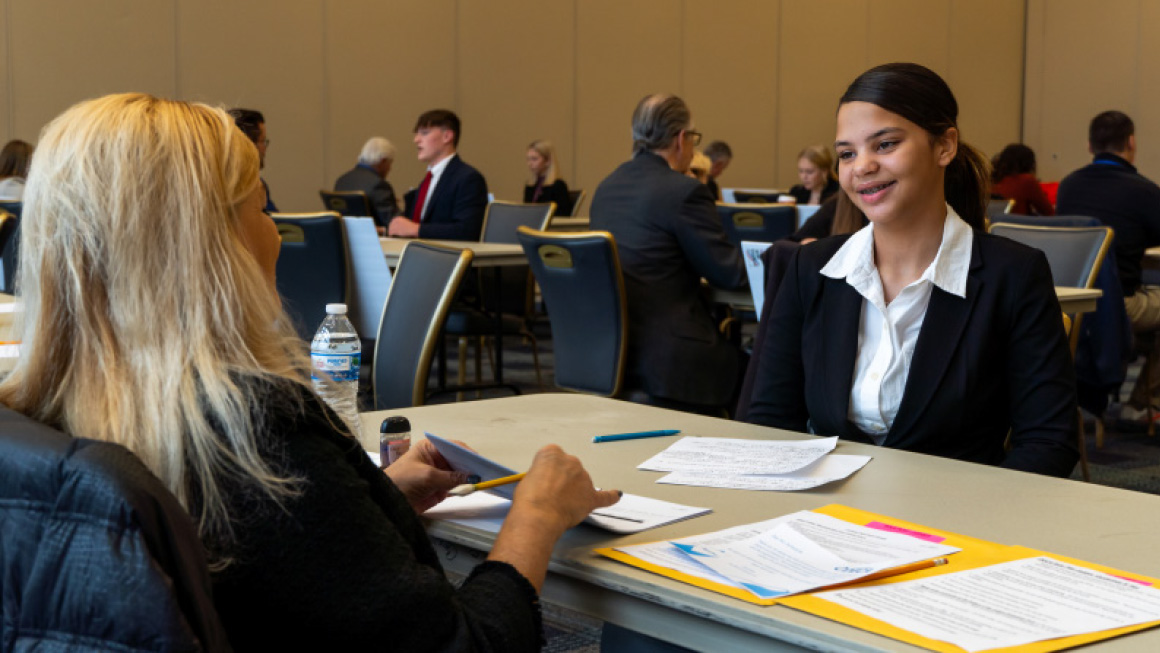 Image from the 2023 DECA Conference. High School student being interviewed.