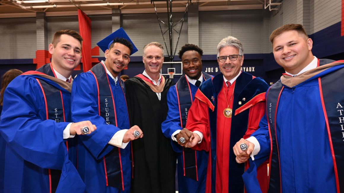 Commencement Speaker, Jack Glover, and President Ken Gormley pose with students showing their Duquesne athletic rings.