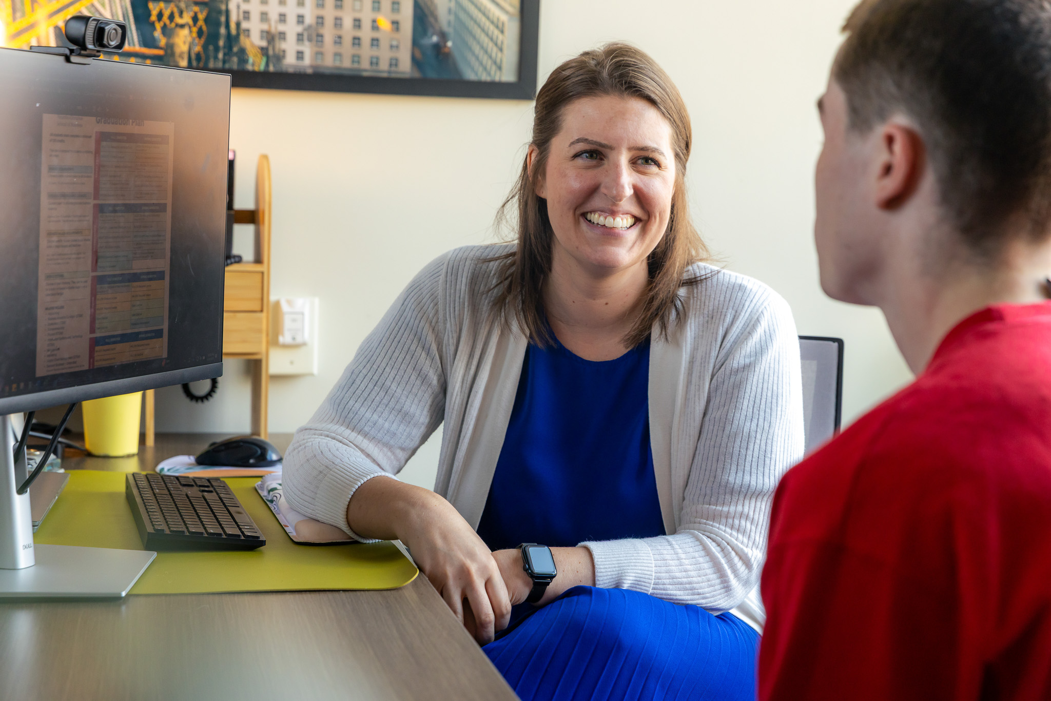 A student success coach smiles while meeting with her student.