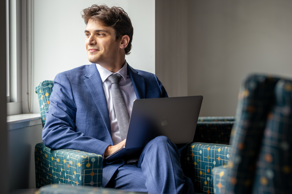 A young business professional gazes out of a window.
