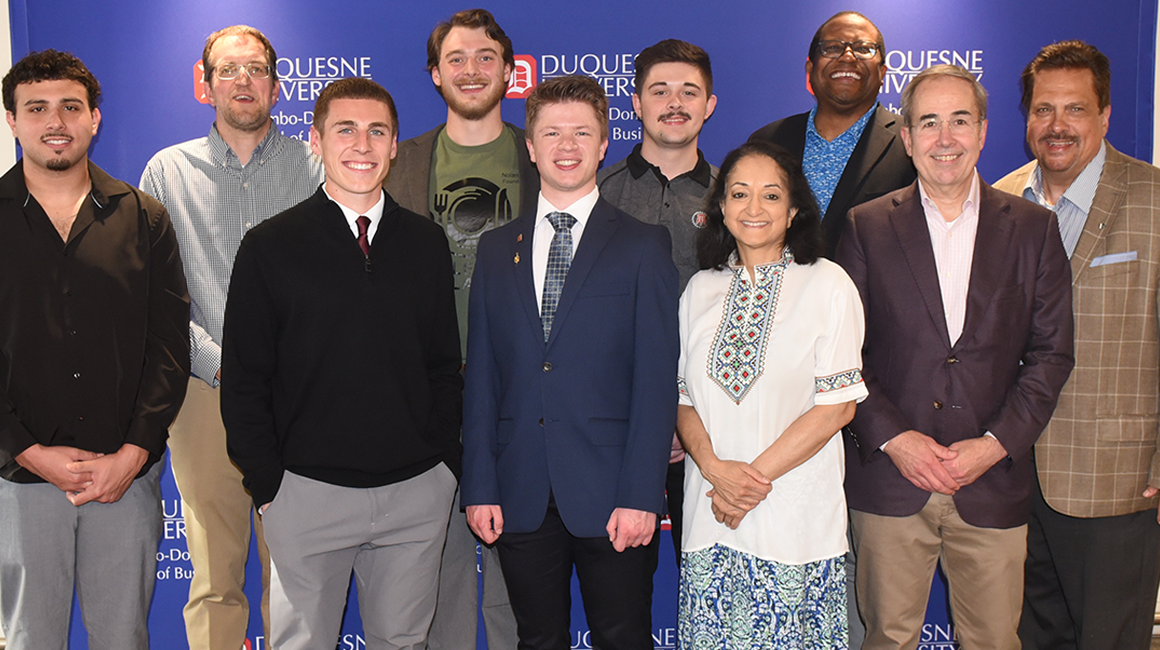 A group of business professionals pose for a photo.