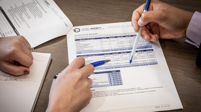 Image of hands and a financial balance sheet