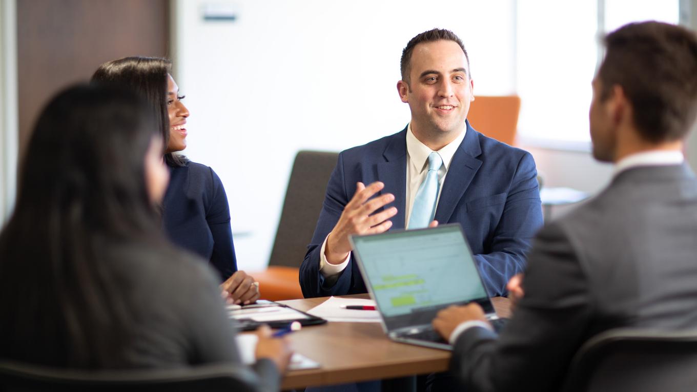 Professionals collaborate at a table. 