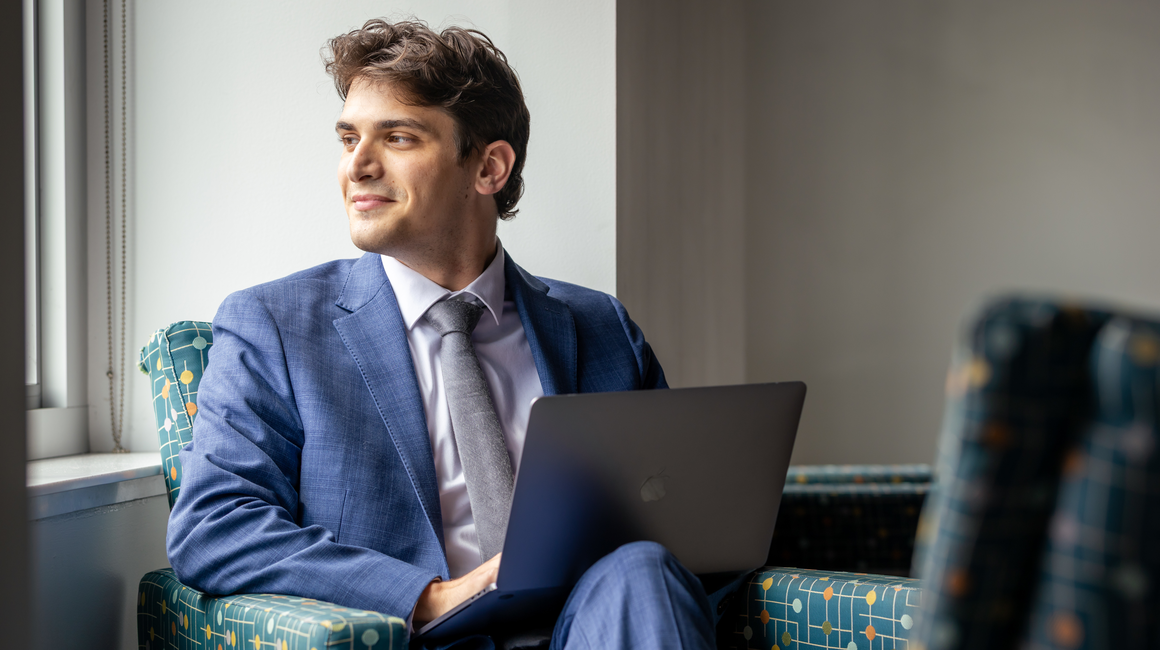 A business professional gazes out a window.