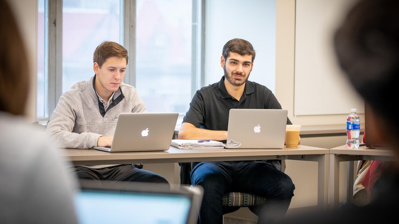 A graduate students smiles during class.