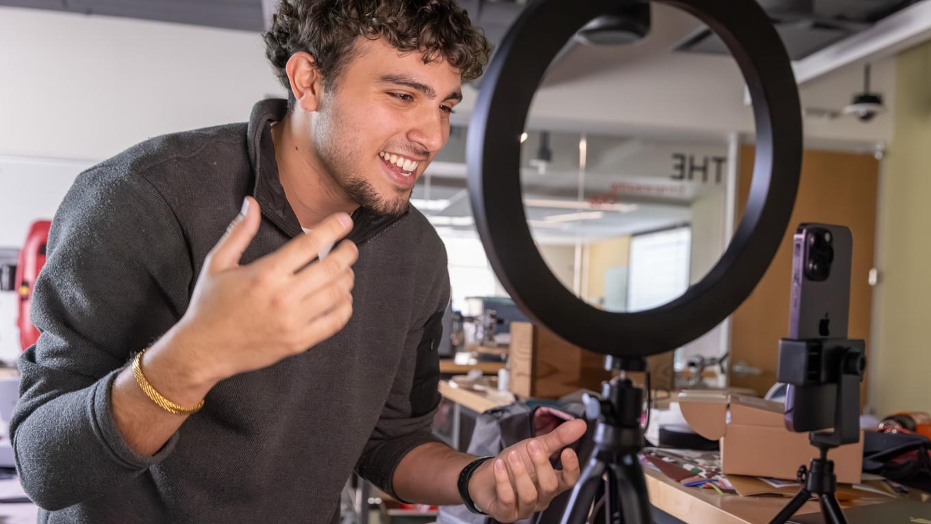 Student filming a video on his phone with a ring light