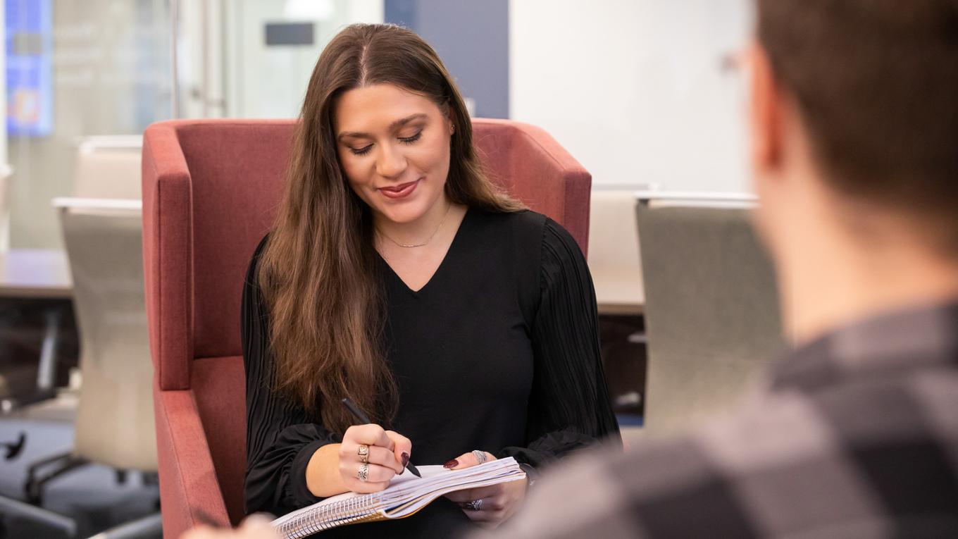 A student looks down at her notebook. 