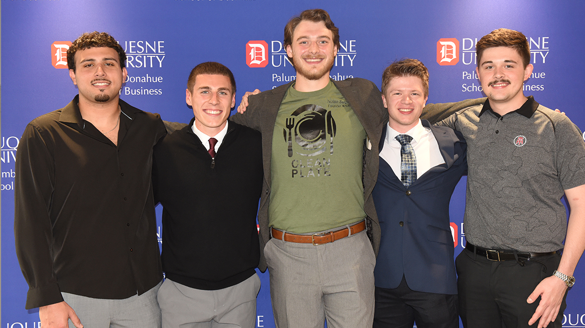 Members of Clean Plate Innovations standing together in front of a School of Business backdrop.