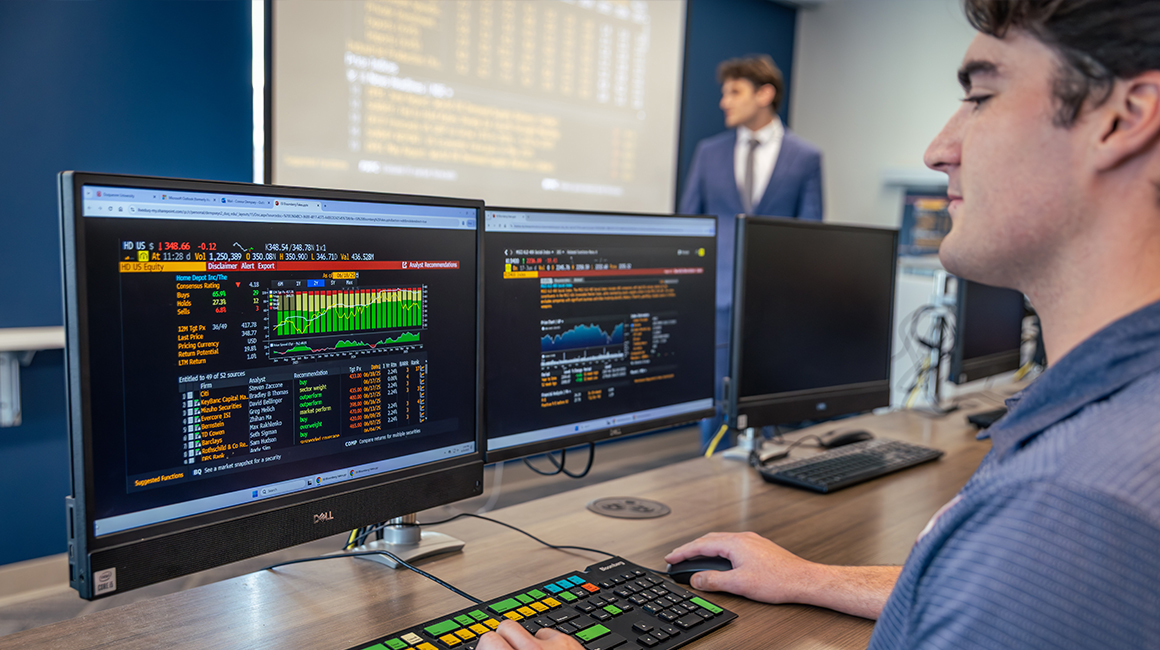 A Duquesne student working at a Bloomberg Terminal in a classroom.