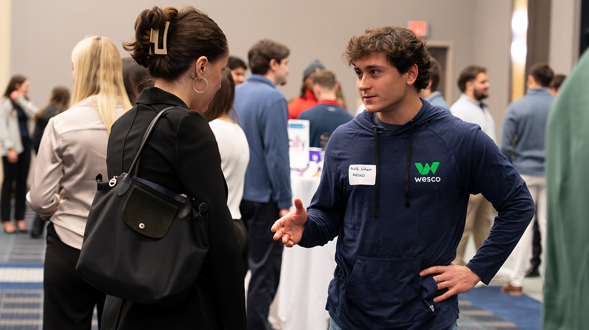 Duquesne student speaking with a Wesco employee at a networking event.
