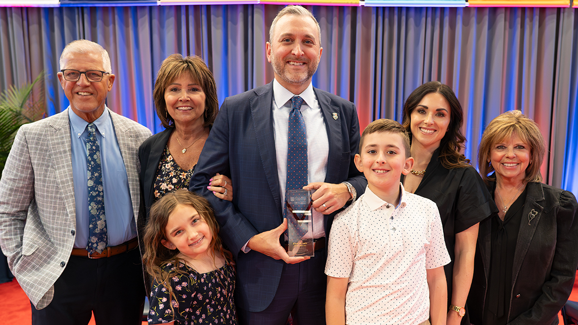 Kevin Lewis, pictured with his family, receives the Palumbo-Donahue School of Business Young Alumnus Achievement Award