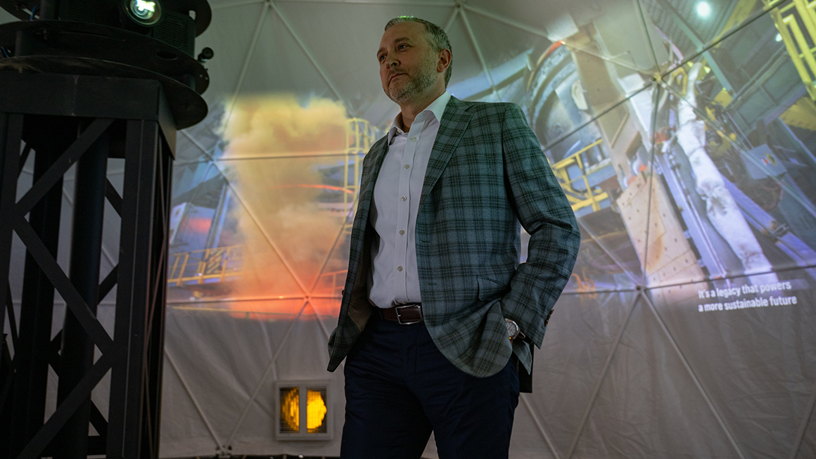 Kevin Lewis standing in front of projected images of U.S. Steel