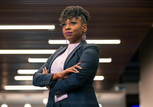 Photo of business woman, standing strong, with arms crossed.