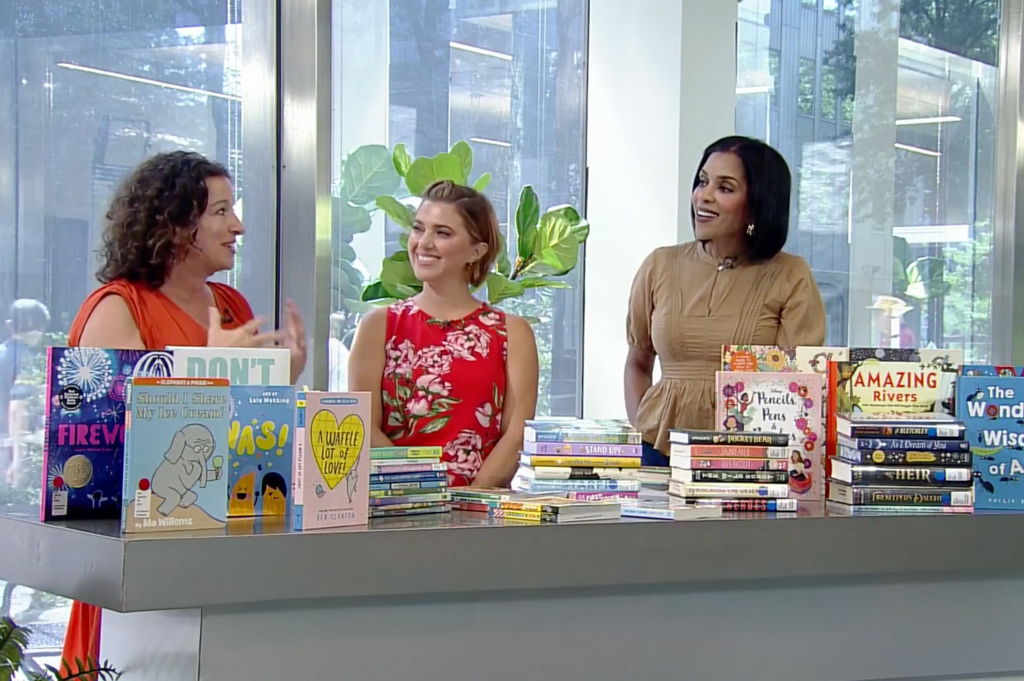 Curriculum Center Director and graduate reading program alum Danielle Henzler on set of Talk Pittsburgh TV show surrounded by books and two co-hosts.
