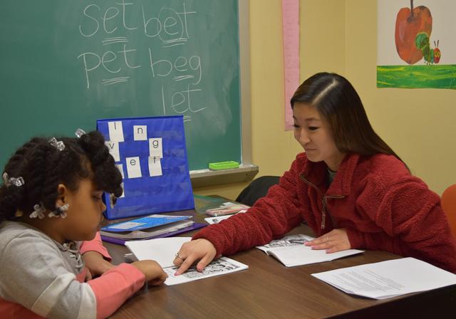 Graduate student with K12 reading clinic learner in reading room engaging in guided individualized lesson