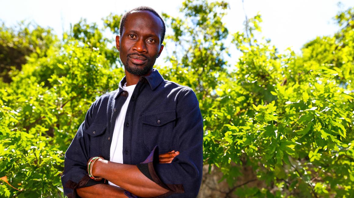 Cliff Oliech outside with green leaves and trees for backdrop