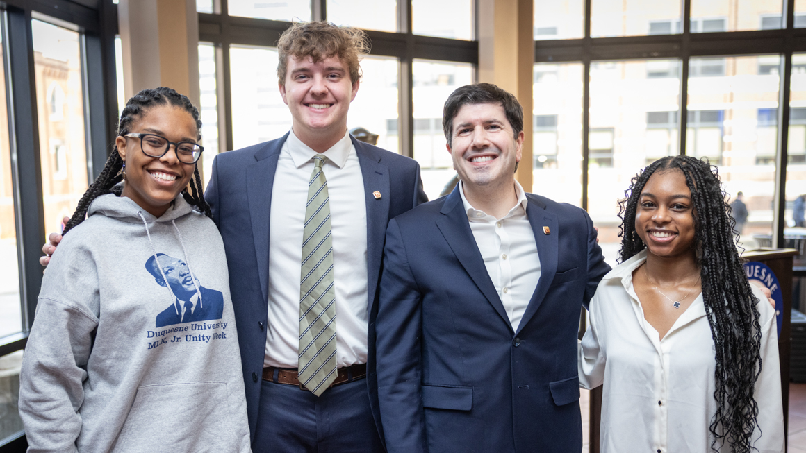School of Education's Jayla Flenory far right standing next to Dr. Dausey and colleagues at inside big windowed building during MLK Jr. Unity week.