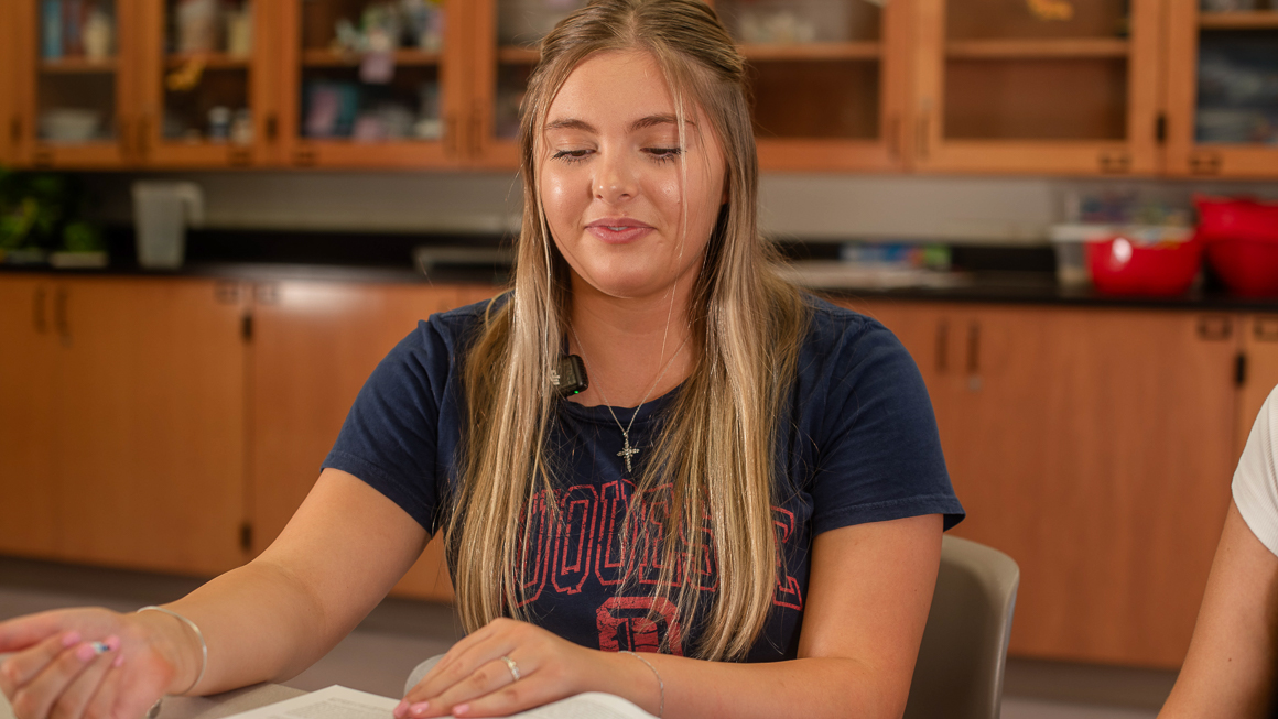 Student teacher engaging in lesson at desk