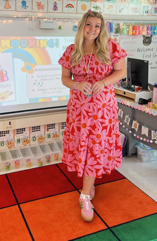 School of Education alum Alexa Nye in 1st grade classroom in front of board