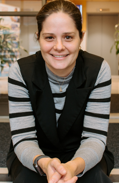 School of Education special education professor Dr. Bridget green sitting with hands folded on Canevin Hall inside entrance steps