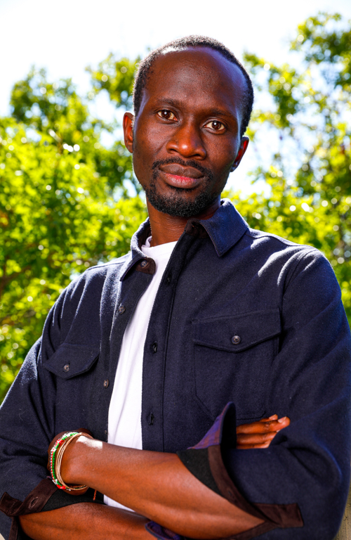 Dr. Cliff Oliech profile photo with green trees in background