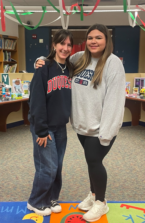 School of Education colleague with Kenzie Bole earring Duquesne sweaters in Early Childhood education library setting in field experience.