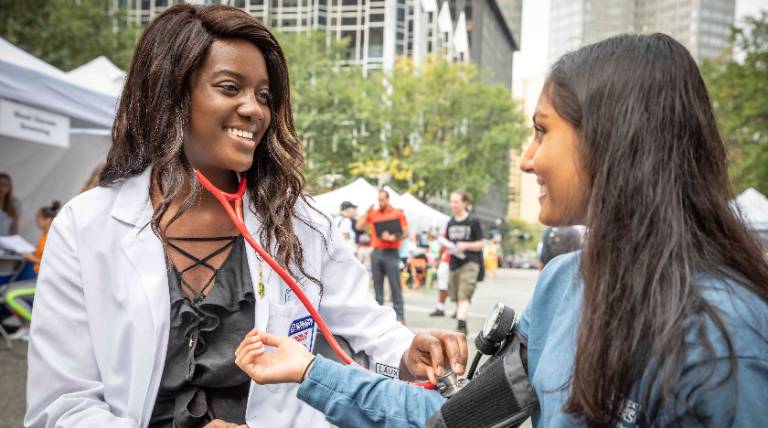 Pharmacy student taking blood pressure of another student.