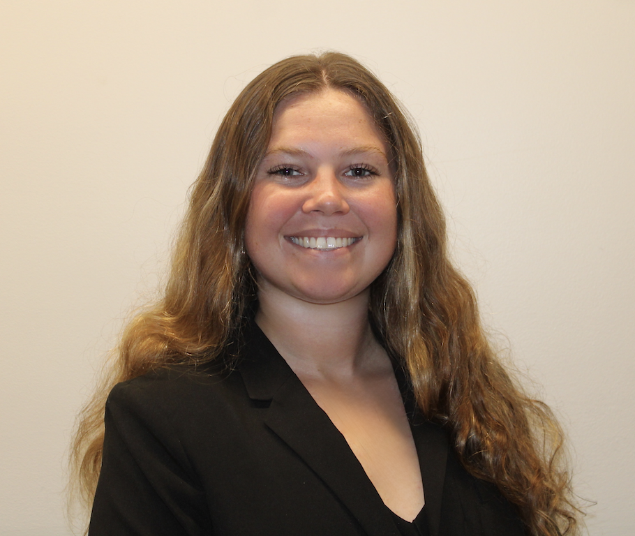 Extern Bella Thomeier smiling in black suit