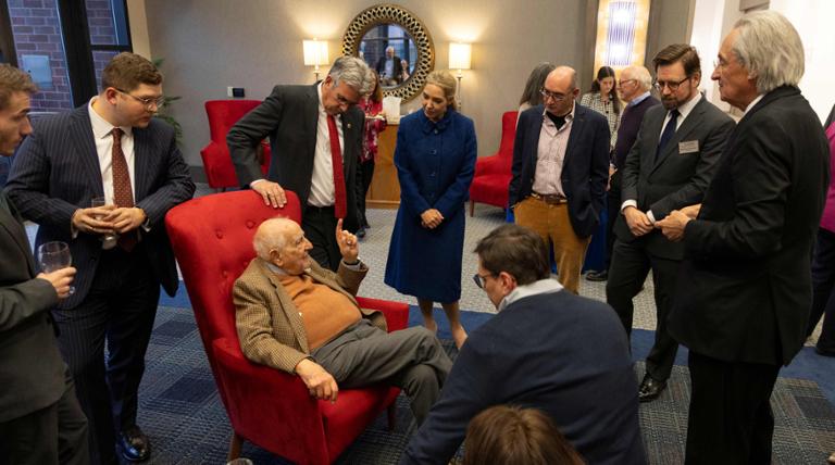 People standing and smiling with Judge Guido Calabresi