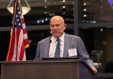 William Goodrich speaking at a podium