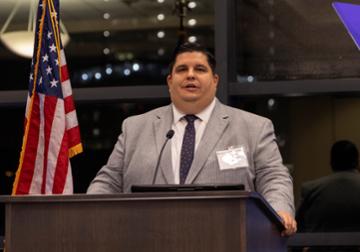 Joseph R. Williams speaking at a podium