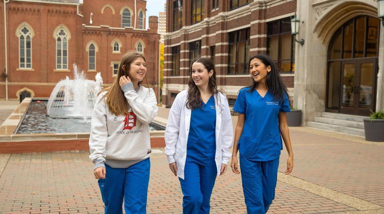 Nursing students walking outside of Canavin Hall. 