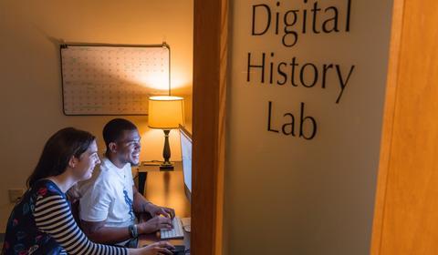 Two students on a MacBook in the Digital History Lab