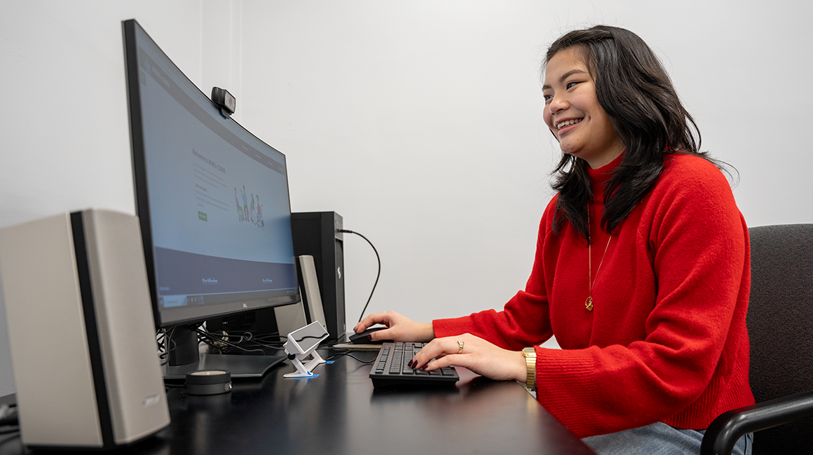 Woman using a computer in a lab with eye tracking device