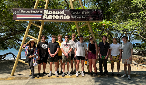 Group of students and their professor in Costa Rica underneath the Parque National Park sign.