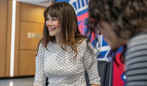 Lexi Javorsky smiling at other students against a Duquesne themed wall 
