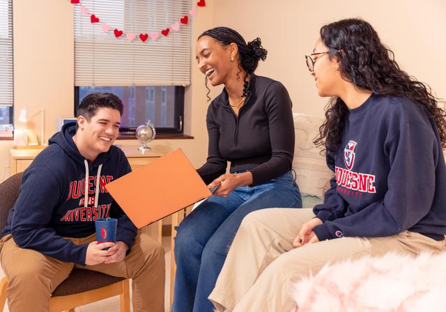 Group of students working together in a dorm room.