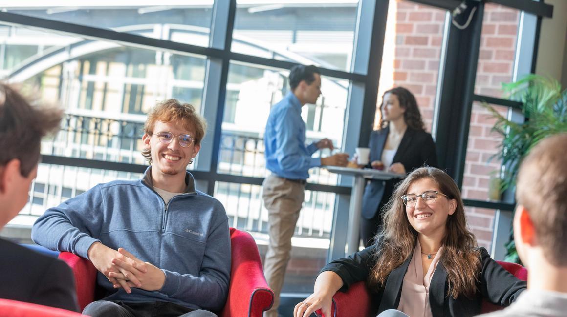 Economics students engaging in conversation during networking event.