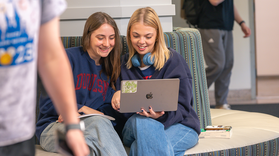 Students discussing coursework in College Hall lobby.