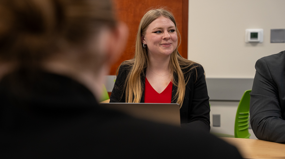 Student in professional attire discussing international policy during simulation.