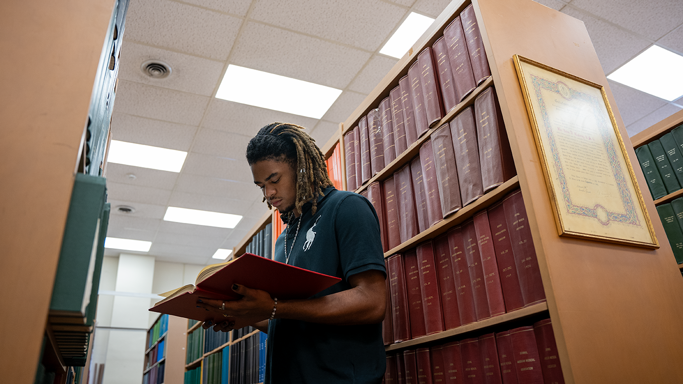 Student reading book in archive.